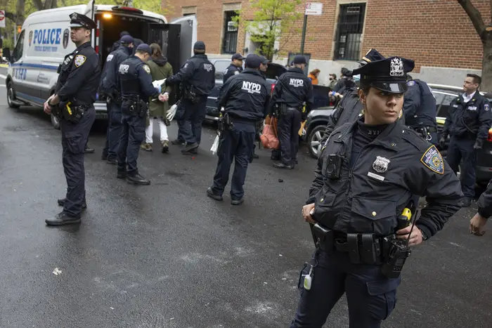 Police enforce a sweep of a homeless encampment, throwing tents and other possessions of the homeless in a trash truck in the East Village in May.